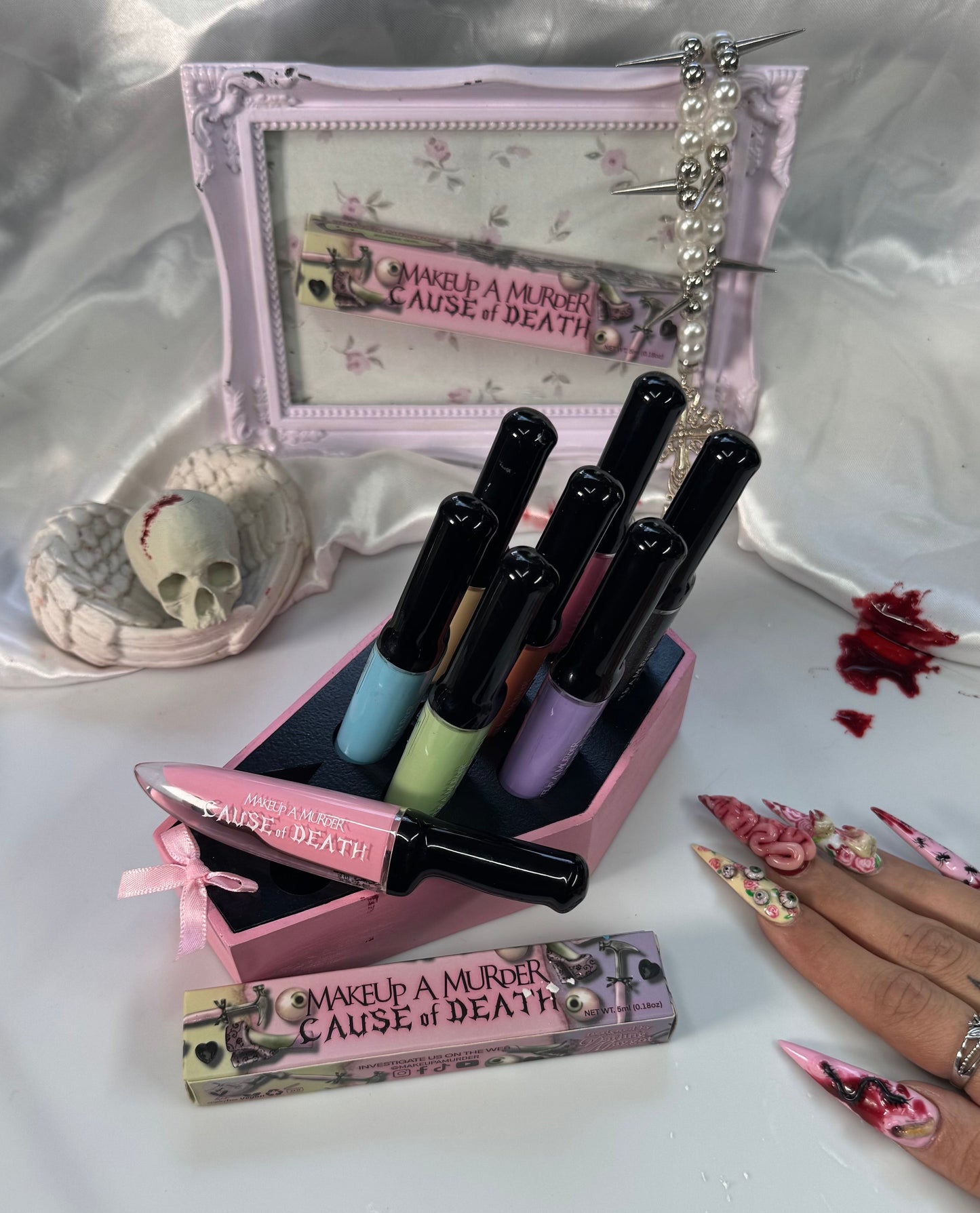 Makeup set with lipsticks and a small mirror on a white surface.