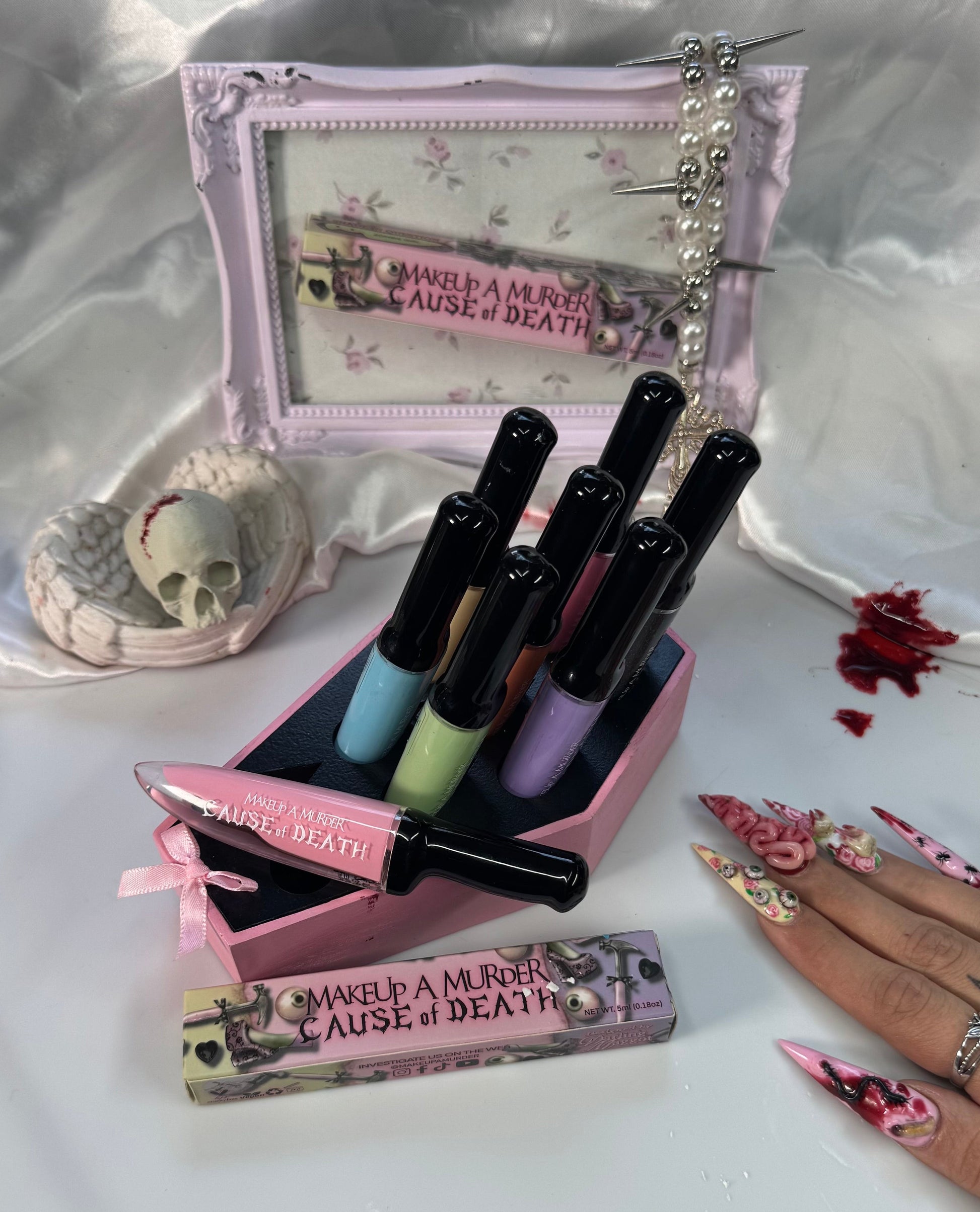 Makeup set with lipsticks and a small mirror on a white surface.