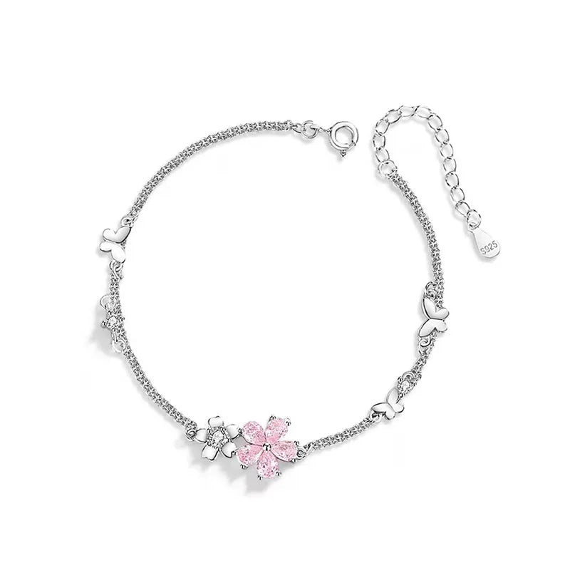 Silver bracelet with pink floral charm on a white background
